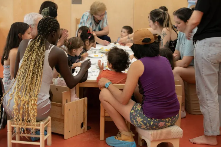 Familias con niños alrededor de una mesa durante el Espacio Familiar de Crianza Municipal