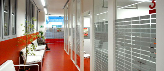 Photo: P. de Grenet Woman sitting on a bench waiting to be seen in social centre corridor