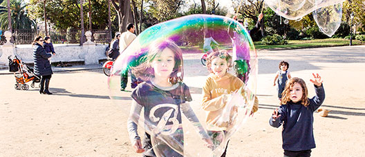 Foto: P. de Grenet Grupo de niños y niñas corriendo por el parque de la Ciutadella siguiendo una burbuja de jabón