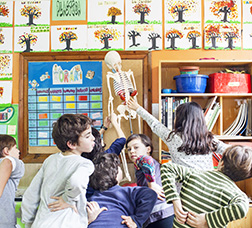 Foto: P. de Grenet Grup de nens i nenes a la sortida de l'escola abraçant-se i rient